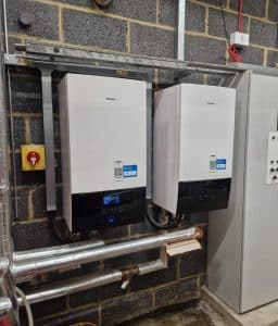 A picture of 2 air source heat pump control panels inside a sports centre