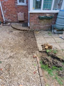 A picture of a customers driveway after leak detection and repair. It shows the stone driveway restored to it's previous condition, with darker stones around the area of repair due to increase water and soil presence.