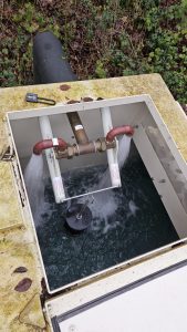 A picture of a water storage tank attached to a booster pump