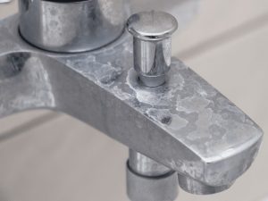 A picture of a bath tap with limescale residue on it